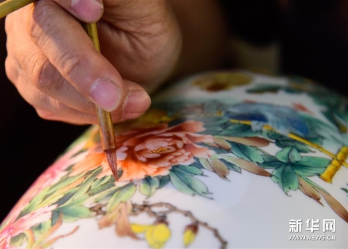 在广辉彩瓷艺术工作室，谭广辉绘制广彩瓷花纹图案（6月3日摄）。