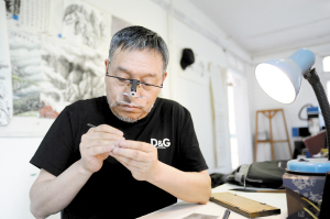 学习微雕要耐得住寂寞，冉隆泉在工作室里创作常常一坐就是一天。